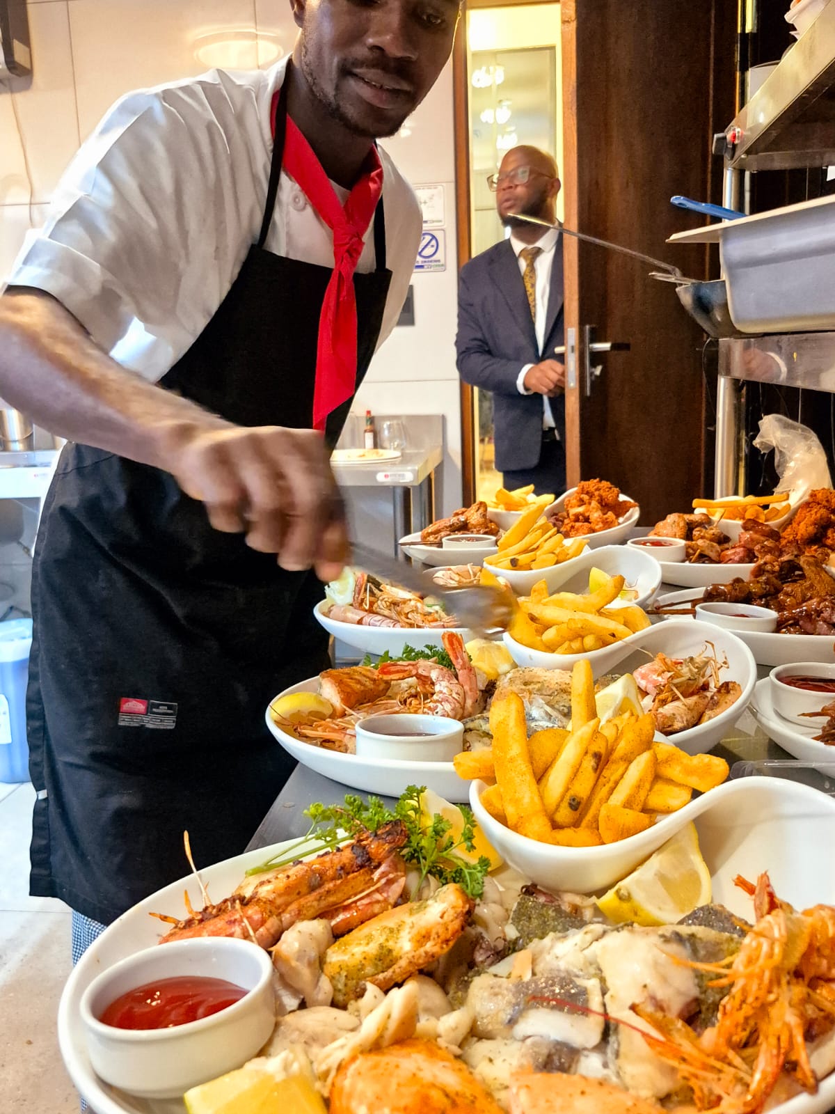Chef finishing a long buffet line of platters before service